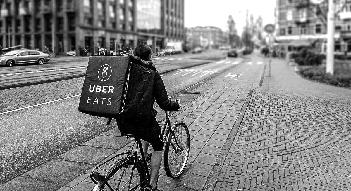 Man riding bicycle with uber eats backpack
